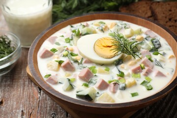 Delicious okroshka soup with kefir served on wooden table, closeup