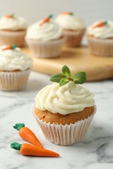 Delicious carrot cupcake with mint on white marble table, closeup
