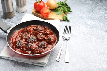 Delicious meatballs with tomato sauce and herbs in served on grey table