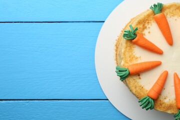 Delicious homemade carrot cake on light blue wooden table, top view. Space for text