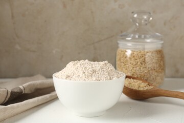 Brown rice and flour on white table. Space for text