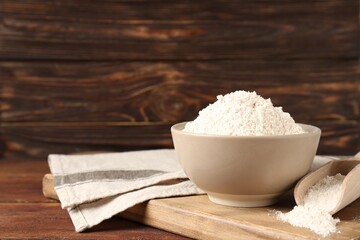 Brown rice flour on wooden table. Space for text