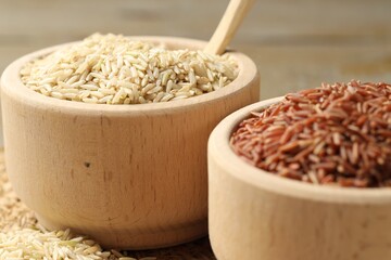Different sorts of raw brown rice on table, closeup