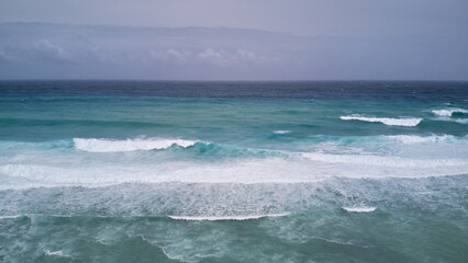 Aerial view of powerful high waves crashing in the Indian Ocean during a cyclone in Mauritius, capturing the intensity of the storm