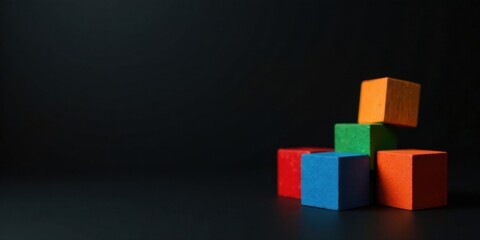 Obraz premium Colorful Wooden Blocks Arranged on Dark Surface, Representing Abstract Concepts of Construction, Growth, and Design