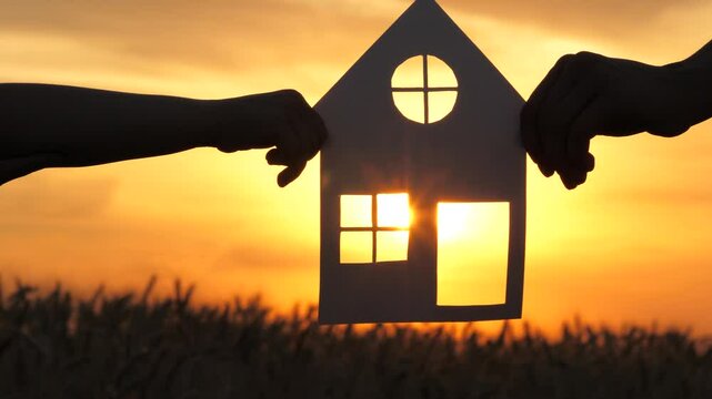 paper house ricky sunset. sunlight window. buying real estate living. House rent. happy family. paper house baby hands mom sunlight. holding hands together. mortgage. real estate concept. credit.
