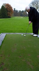 Fototapeta premium Senior Man Practicing Golf Swing on the Green Fairway Under Overcast Sky in a Golf Course