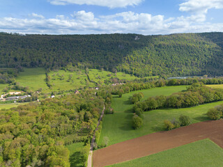 Landscape in inland France with fields, mountains and forests, drone shot in spring