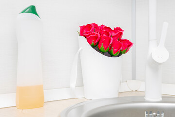 a bouquet of red roses made of soap stands in the kitchen near the sink. soap flowers near the sink. red soap roses. 