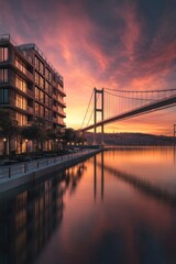Obraz premium Sunrise cityscape with modern building and bridge reflecting in calm water.