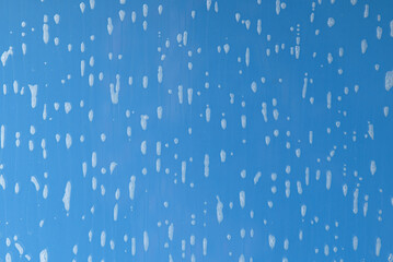soap foam on window glass, blue background, spring cleaning, abstract pattern