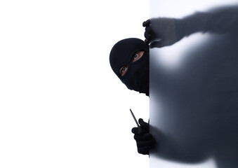 Studio shot of a stealthy thief breaking into a room and carefully looking around isolated on white...