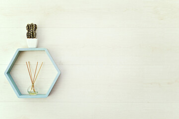 hexagonal wooden shelf on the wall with flowers and aroma diffuser. mock up