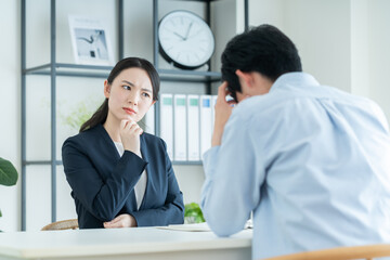 悩む若い男性の相談にのるプランナーの女性