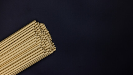 Paper straws on black background, Paper straws, Accessories for drinking outdoors, Ecology recycling eco friendly, Eco friendly reusable paper straws, Kraft paper straw for drinking coffee or tea.