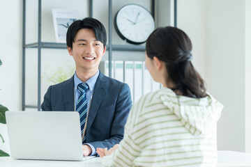 若い女性に提案するプランナーの男性