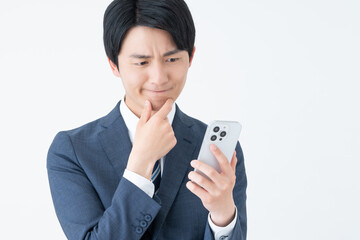 スマホで悩む若いビジネスマン