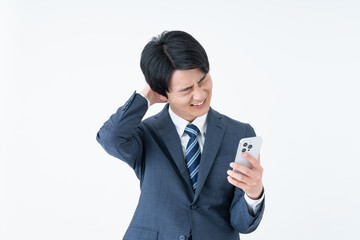 スマホで悩む若いビジネスマン