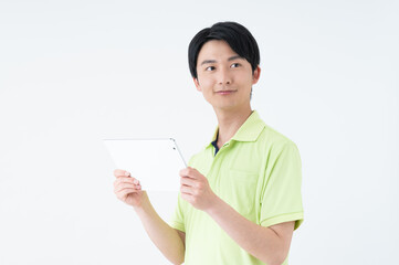 タブレット端末を持つ介護福祉士の若い男性