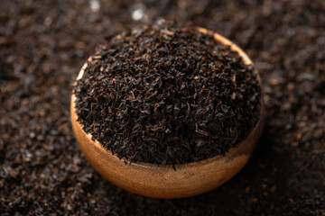 Dry black tea leaves in bamboo bowl. Eco tea drinking utensils.