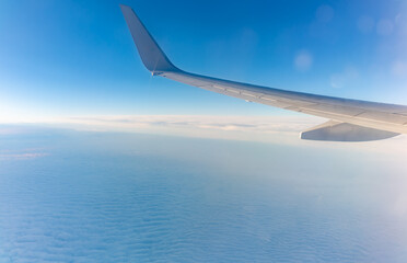 Obraz premium View from the airplane window at a beautiful cloudy sky and the airplane wing
