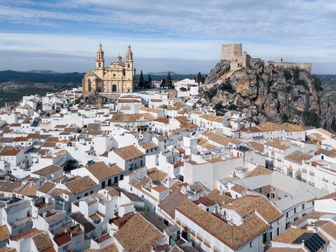 Catholic cathedral and ancient castle on hill top above ancient white town, Olvera, Andalusia, Spain