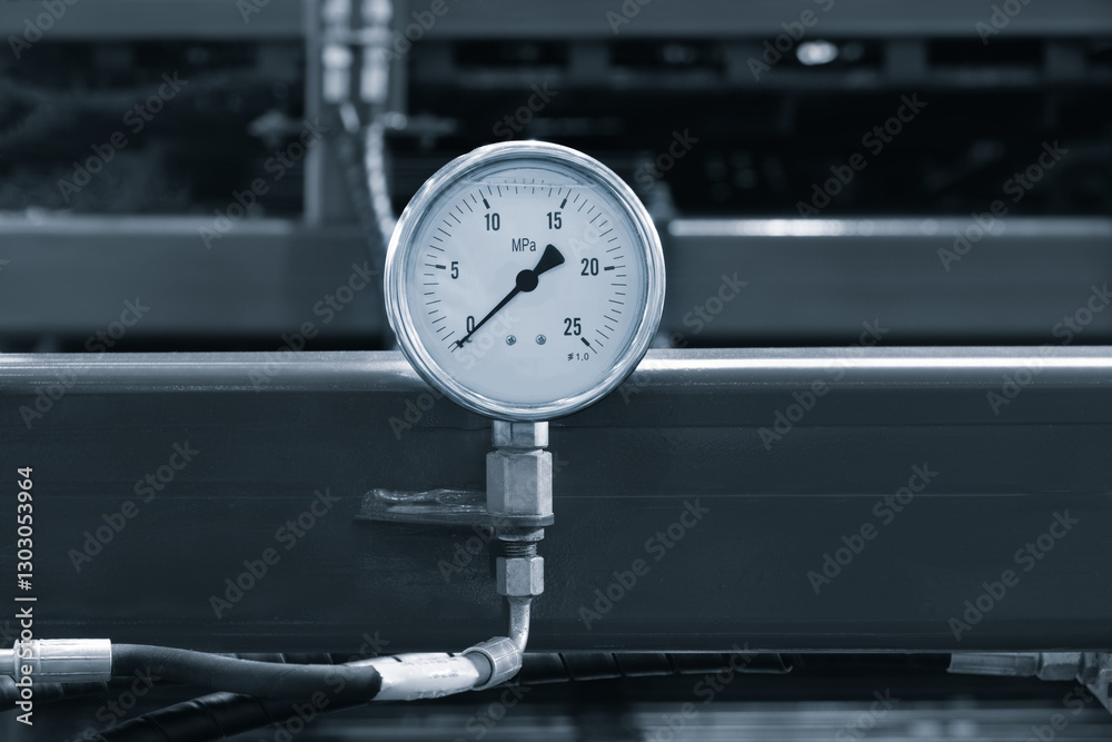Poster a pressure gauge is on a metal surface. the gauge is white and has a black face. the numbers on the 