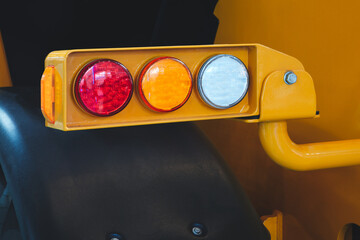 Yellow light pole with three lights on it. Lights are red, yellow and white. Rear signal lights of...