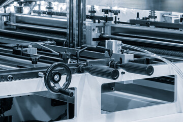 Automatic polyethylene plastic bag production machine with lighting effect. Close-up of the roller...