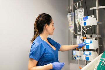 Nurse adjusting medical equipment in hospital setting