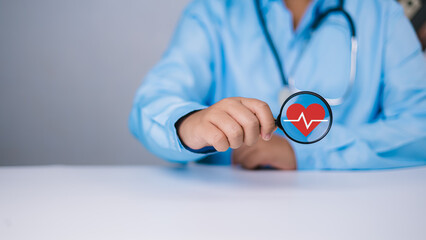 Health insurance and medical check up concept, Medical information search, Doctor hold magnifying glass with red heart icon, Treating disease, Insurance concept, Concept for commercial business.