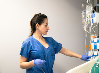 Nurse adjusting infusion pump settings in hospital room