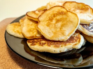 A stack of fried pancakes on a black plate