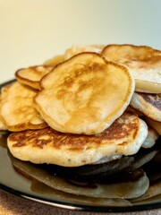 A stack of fried pancakes on a black plate