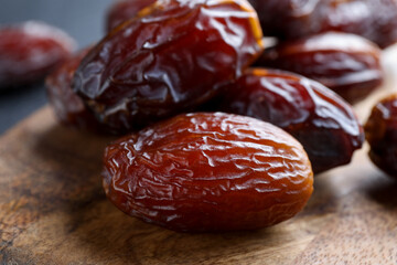 Tasty dried dates on wooden board, closeup