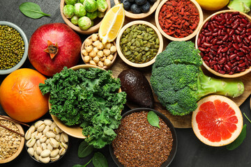 Different superfood products on black table, flat lay