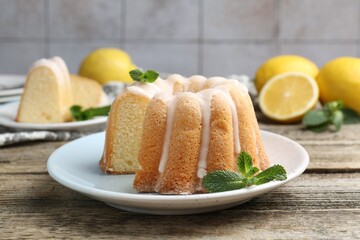 Delicious lemon cake with glaze and mint on wooden table, closeup