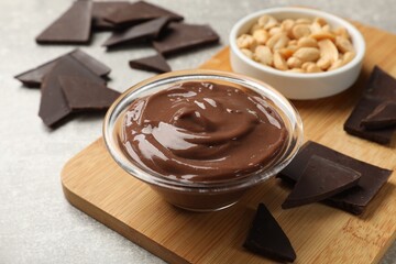 Delicious chocolate mousse in glass bowl and ingredients on grey table, closeup