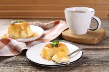 Delicious pudding with caramel sauce and mint served on wooden table