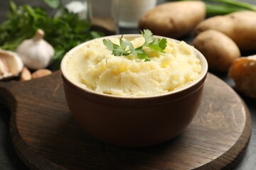 Delicious mashed potato with parsley in bowl on table, closeup