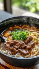 Steam rises from a bowl brimming with rich beef noodle soup