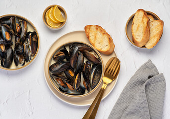 Food photography of mussels with garlic and butter sauce, lemon, toasted bread, seafood appetizer with creamy sauce, starter
