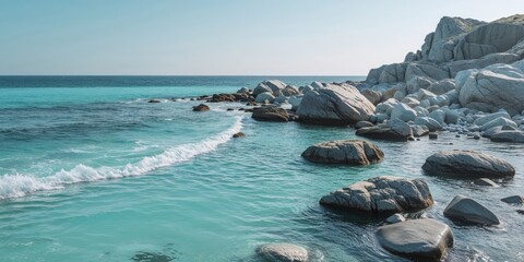 Clear turquoise water with rocks along rugged coastline.