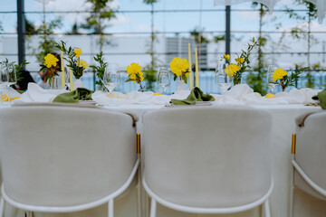 Elegant Dining Table Setting with Yellow Flowers and Candles