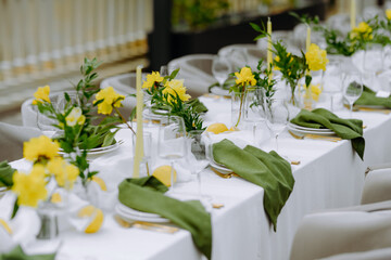 Elegant Table Setting with Yellow Flowers and Green Napkins for a Celebration