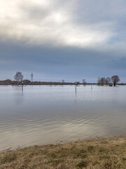 Body of water is surrounded by trees and a power line