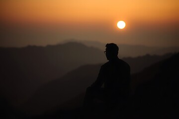 Warm and Soft Lighting with Subtle Darkness Highlighting a Man's Seated Silhouette in Vibrant Colors