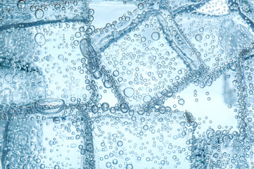 Refreshing soda water with ice cubes against white background, closeup