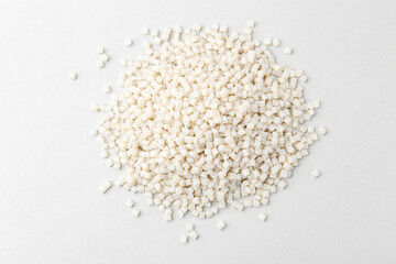 Pile of plastic granules on white background, top view
