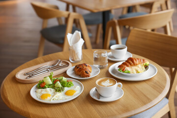 Delicious breakfast served on wooden table in cafe